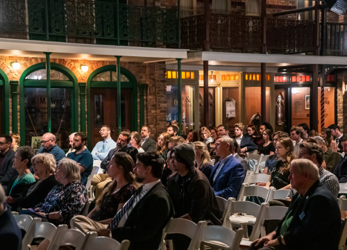 Guests sit in the audience at a lecture series at the Pensacola Museum of Commerce